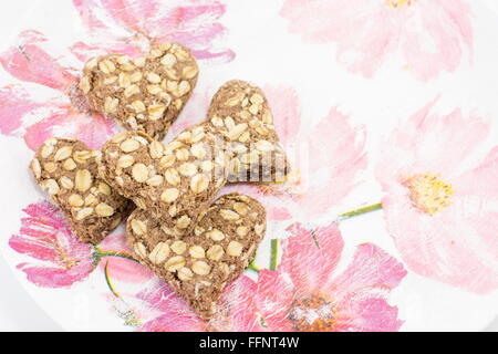 Heartshaped cookies faits de farine intégrale sur un plateau decoupaged Banque D'Images