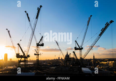 Grues à tour sur la nouvelle Place Bloomberg office développement dans la ville de London, EC4 qui se profile à l'horizon au coucher du soleil Banque D'Images