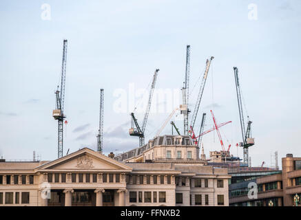 Plusieurs grues à tour sur le site de développement Place Bloomberg ci-dessus les toits de bâtiments dans la ville de London financial district, EC4 Banque D'Images