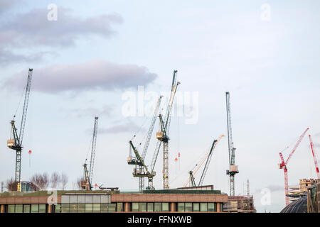 Plusieurs grues à tour sur le site de développement Place Bloomberg ci-dessus les toits de bâtiments dans la ville de London financial district, EC4 Banque D'Images