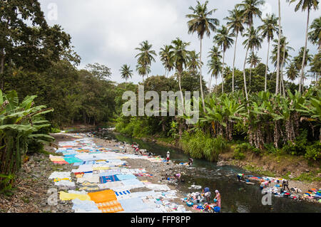 Les femmes africaines à laver les vêtements sur une rivière. Les vêtements sont lavés menti sur la rive de la rivière pour sécher au soleil. Banque D'Images