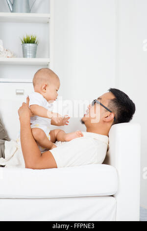 Père jouer avec bébé garçon à l'intérieur. Vie de famille asiatique à la maison. Banque D'Images