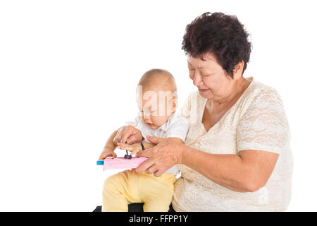 Grand-mère et petit-fils jouer instruments musique ensemble, son concept de développement de bébé, isolé sur fond blanc. Banque D'Images