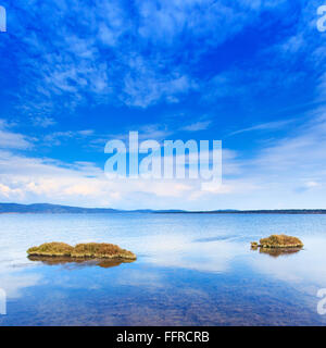 Deux petites île verte dans un lac bleu sous un ciel clair. Orbtello lagoon, Toscane, Monte Argentario, Italie. Banque D'Images