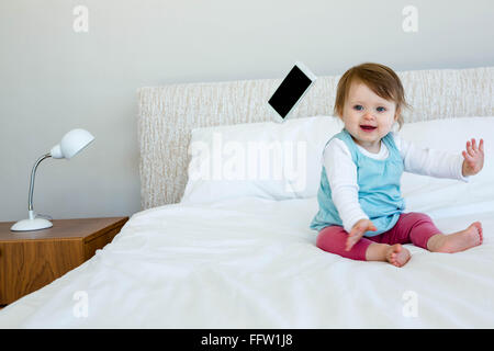 Adorable bébé rire et à lancer un téléphone Banque D'Images