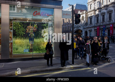Shoppers attendre pour traverser la route en dehors de la direction de la mode britannique Piccadilly Cath Kidston marque sur le coin de la rue Duke, le centre de Londres. Banque D'Images
