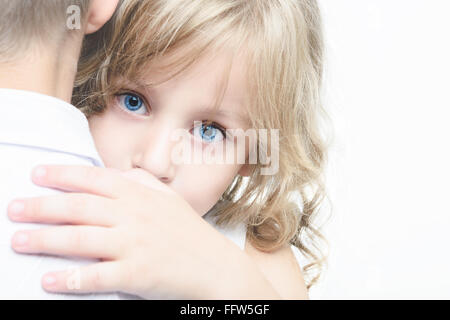 Belle petite fille regarde au-dessus de l'épaule du garçon Banque D'Images