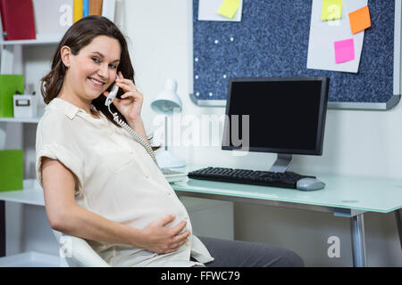 Femme enceinte sur le téléphone Banque D'Images