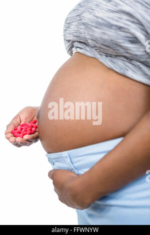 Pregnant woman holding pills dans sa main Banque D'Images