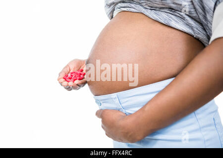 Pregnant woman holding pills dans sa main Banque D'Images