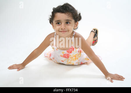 Jeune fille de 4 ans portant sur l'humeur ludique la masse sur le ventre avec les deux mains ouvertes et smiling MR n° 687D Banque D'Images