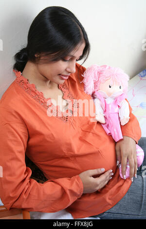 Les Indiens de l'Asie du Sud young pregnant lady holding a baby doll et obtenir M. nostalgique# 687 Q Banque D'Images