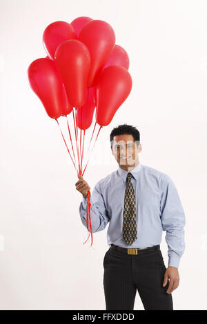 Businessman holding red couleur gaz ballons dans une part monsieur# 703T Banque D'Images