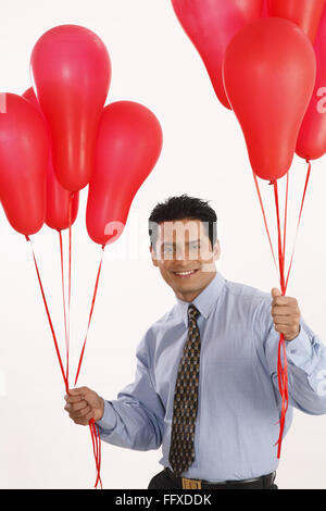 Businessman holding red couleur gaz ballons dans les deux mains MR# 703T Banque D'Images