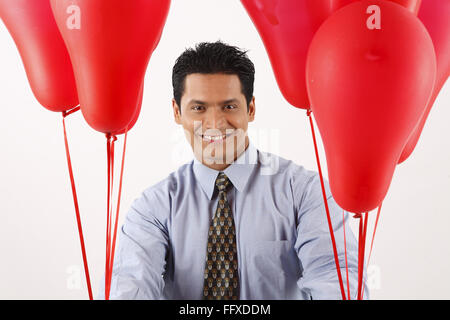 Businessman holding red couleur gaz ballons dans les deux mains MR# 703T Banque D'Images