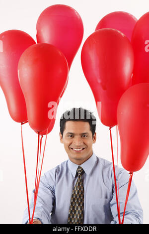 Businessman holding red couleur gaz ballons dans les deux mains MR# 703T Banque D'Images