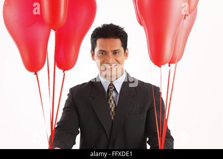 Businessman holding red couleur gaz ballons dans les deux mains MR# 703T Banque D'Images