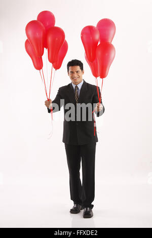 Businessman holding red couleur gaz ballons dans les deux mains MR# 703T Banque D'Images