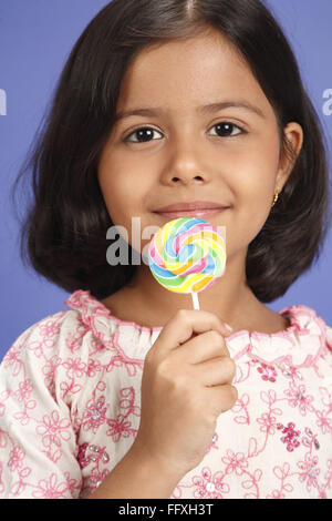 Fillette de huit ans holding large colorful lollipop MR# 703U Banque D'Images