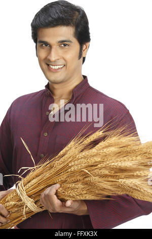 Indian farmer holding bundle riche de cultures de blé d'or récoltés MR n° 743A Banque D'Images