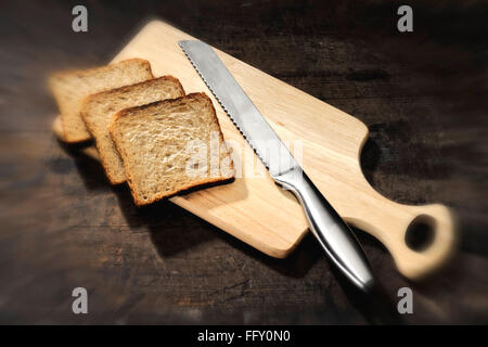 Les choses de cuisine , le pain avec couteau à pain sur la planche à découper en bois Banque D'Images