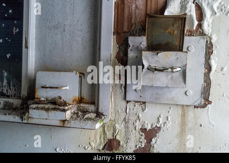 Vieux et brisé sortir coffre intégré dans un mur qui a été vandalisé Banque D'Images