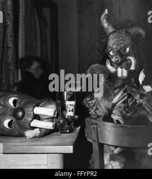 Festivités, Perchtenlaufen, Percht avec masque en bois assis dans le pub, Kirchseeon, 1959, droits-supplémentaires-Clearences-non disponible Banque D'Images