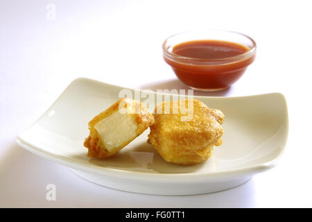 La cuisine indienne , Pakode Fromage entrées fast food Les inhalations servi avec le ketchup dans plat sur fond blanc Banque D'Images