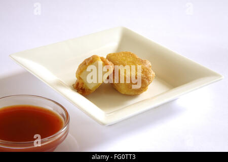 La cuisine indienne , Pakode Fromage entrées fast food Les inhalations servi avec le ketchup dans plat sur fond blanc Banque D'Images