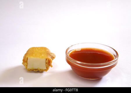 La cuisine indienne , Pakode Fromage entrées fast food Les inhalations servi avec le ketchup dans plat sur fond blanc Banque D'Images