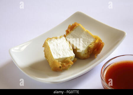 La cuisine indienne , Pakode Fromage entrées fast food Les inhalations servi avec le ketchup dans plat sur fond blanc Banque D'Images