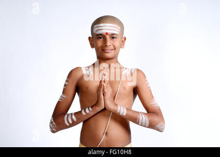 Un petit garçon hindou indien portant un fil sacré rouge tilak blanc frêne shavite symbole Doing Namaskar Inde MR#719 Banque D'Images