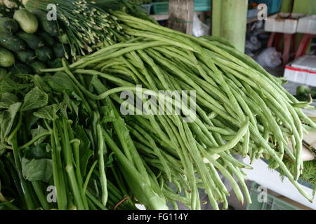 Les haricots et autres légumes Yardlong sur un étal à Bangkok, Thaïlande Banque D'Images