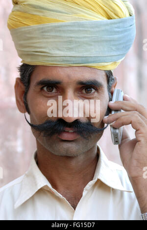 L'homme du Rajasthan avec moustache holding cell phone , Jodhpur, Rajasthan, Inde M.# 682 E Banque D'Images