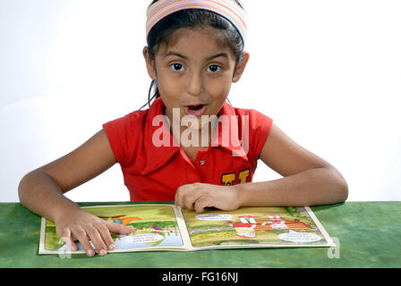 Les Indiens de l'Asie du Sud 6 ans girl reading comic book MR# 364 Banque D'Images