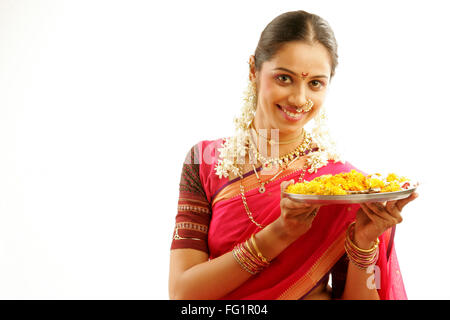 South Asian girl wearing Maharashtrian indienne sari traditionnel navwari gajra bijoux appropriés holding pooja Thali Banque D'Images