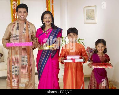 Mother holding pooja thali avec family holding gift boxes standing in house M.# 702R,MR# 702S,MR# 702T,MR# 702U Banque D'Images