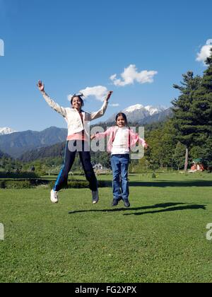 Jeunes filles sautant de joie à l'Indira Gandhi park ; Pahalgam ; Jammu-et-Cachemire en Inde ; M.# 477 Banque D'Images