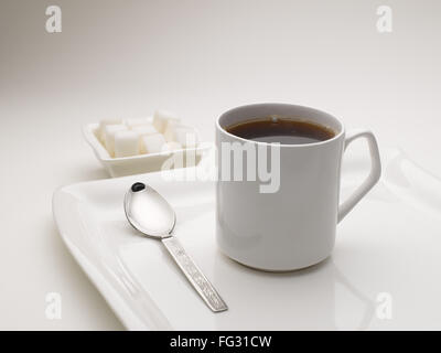 Tasse de thé noir en plat de service avec des morceaux de sucre l'Inde Banque D'Images