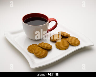 Tasse de thé noir en plat de service avec des biscuits l'Inde Banque D'Images