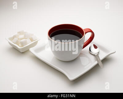 Tasse de thé noir en plat de service avec des morceaux de sucre l'Inde Banque D'Images