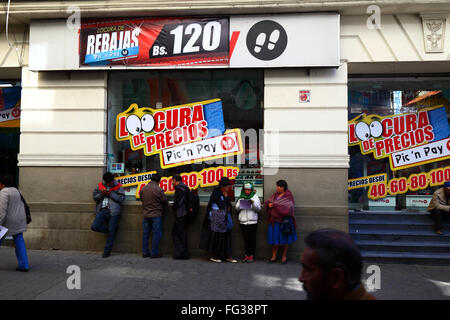 Les gens debout dans la queue devant le magasin discount offrant des réductions de prix folles, Calle Comercio, la Paz, Bolivie Banque D'Images