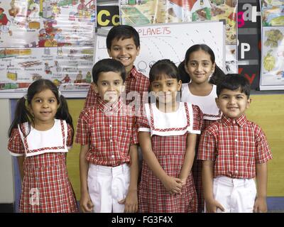 Les Indiens de l'Asie du Sud se tenant ensemble garçons et filles dans l'école maternelle M. Banque D'Images