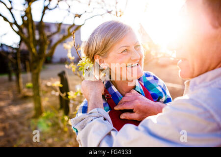 Man, tablier de femme de réglage de couple de personnes âgées, jardin ensoleillé, Banque D'Images