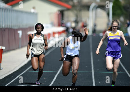 Trois athlètes de l'école secondaire à la souche la ligne d'arrivée de 10 100 mètres d'une école secondaire d'athlétisme. USA. Banque D'Images
