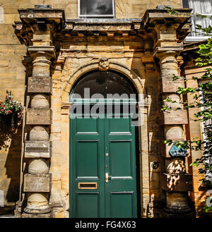 Une entrée de porte verte deux un bâtiment résidentiel historique avec piliers en pierre et porte en arche témoigne de la vieille Angleterre Banque D'Images