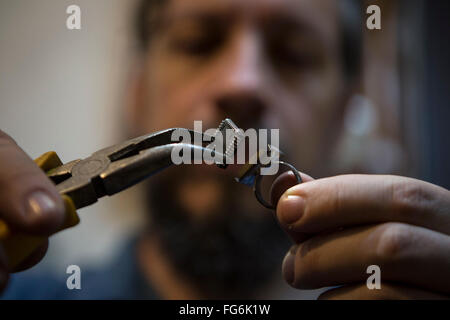 Buenos Aires, Argentine. Feb 17, 2016. Designer Hernan Bressan met une puce obsolètes sur la base d'un anneau dans son atelier à Buenos Aires, capitale de l'Argentine, le 17 février 2016. Hernan Bressan, un expert de l'électronique et responsable de l'électron, initiative souvenirs électroniques réutilise la corbeille pour la prendre comme base de bijoux et accessoires. © Martin Zabala/Xinhua/Alamy Live News Banque D'Images