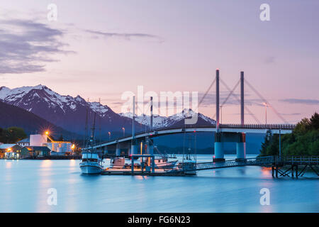 Bateau de pêche amarré le long de la jetée dans le port de Sitka avec le pont O'connell et les montagnes en arrière-plan à Twilight, sud-est de l'Alaska, USA, su... Banque D'Images