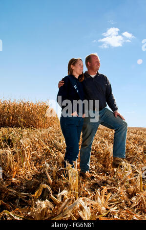 Agriculture - mari et femme posent ensemble dans un champ de maïs-grain récolté en partie à l'automne / près de Sioux City, Iowa, États-Unis. Banque D'Images