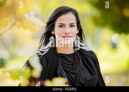 Un jeune autochtone modèle féminin regarde la caméra dans un headshot les épaules jusqu'à l'extérieur prises à l'automne ; Vancouver, Colombie-Britannique, Canada Banque D'Images